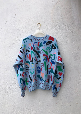 sudadera pintada colgada en gancho